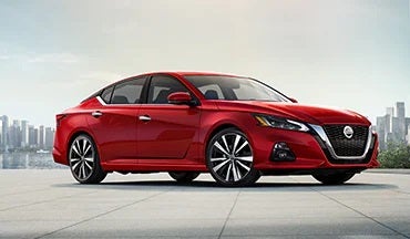 2023 Nissan Altima in red with city in background illustrating last year's 2022 model in Nissan of Gilroy in Gilroy CA